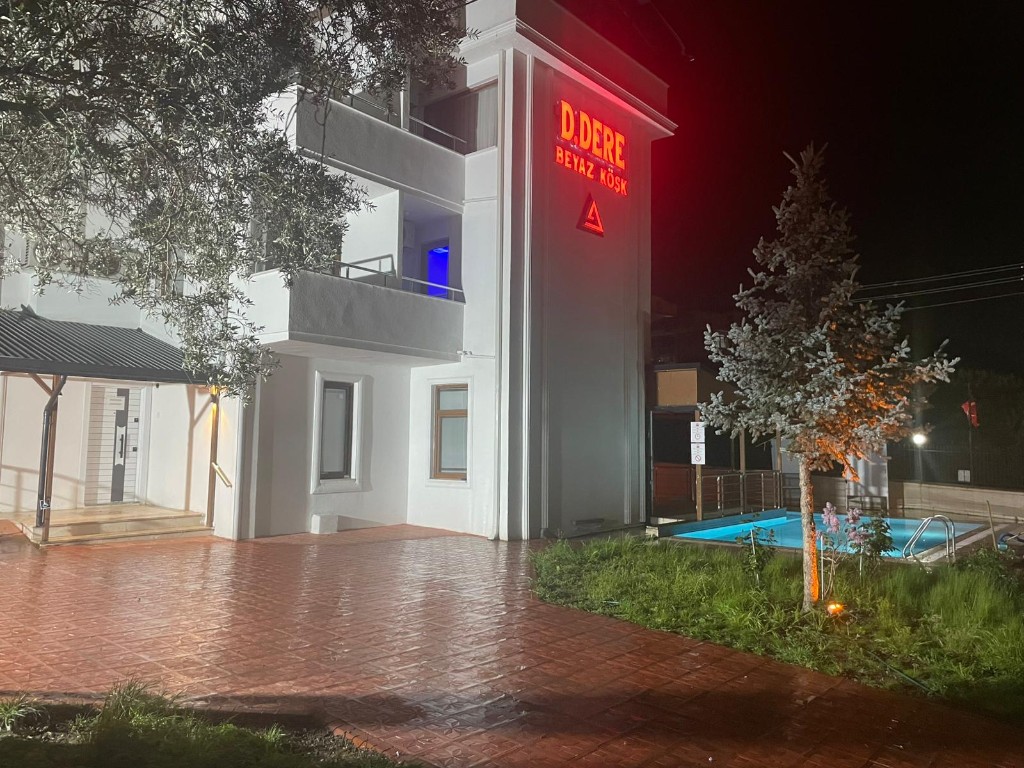 Beyaz Köşk gece cephe, neon tabela ve aydınlatılmış havuz